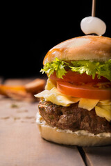 Hambburquesa served on rustic table with dark background