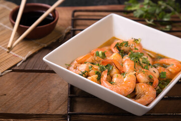 Fried shrimp with shell served with shoyu sauce on rustic wooden table