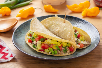 Corn tortilla filled with meat and vegetables on rustic table