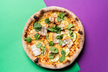 White fish fillet pizza, top view on green and purple background