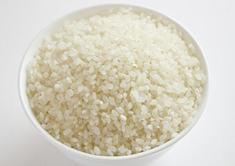 rice grains in a bowl isolated on white background.