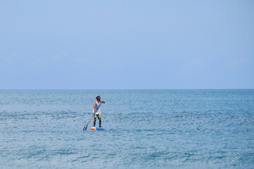 Asian man playing the paddle in kuta beach