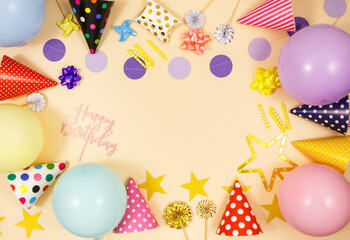 Background for happy birthday celebration or party. Group of colored balloons , confetti, candles, ribbons on beige pastel background. Mock up with copy space, place for text	