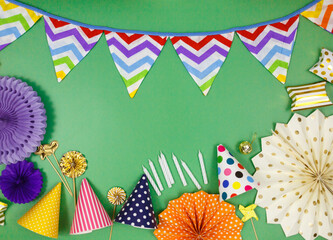 Background for happy birthday celebration or party. Group of colored balloons , confetti, candles, ribbons on green pastel background. Mock up with copy space, place for text	