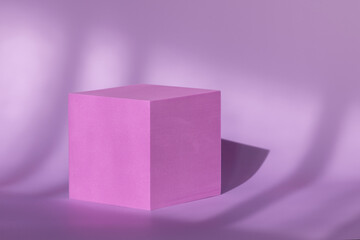 Geometrical podium showcase for cosmetic product presentation. Cube shape platform on shadow background. Purple cubic pedestal for branding and packaging with natural shadows