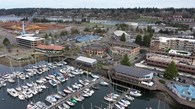 Cinematic bird's-eye view of Percival plaza, the Olympia Farmers Market, Percival Landing Park, East Bay with a panoramic view of Historic District, Capitol building in Olympia, Washington