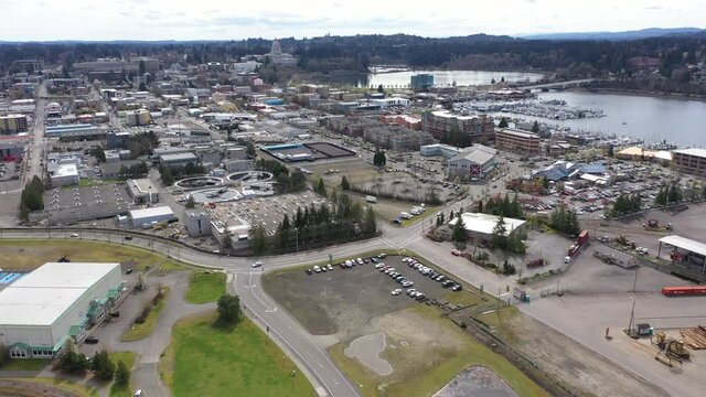 Cinematic orbiting drone footage of downtown Olympia, the Olympia Farmers Market, Percival Landing Park, West Bay with a panoramic view of Historic District, Capitol building in Olympia, Washington