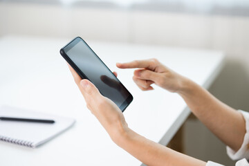 Close up business woman hands using smartphone. Young female texting touching on display of cell phone.