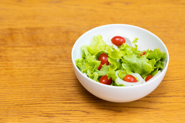 Salad green oak and tomato. Breakfast diet menu. Fresh salad in morning on the wood table.