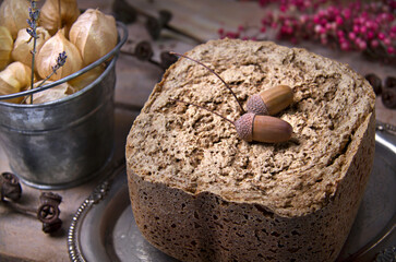Selective focus of artisan bread with acorns, physalis in the background
