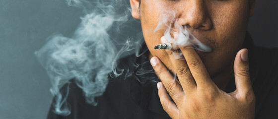 Young men smoking He smoked and spat out a lot of smoke. It is dangerous to the people around