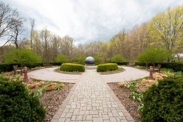 Montgomery,, NY - USA - April 21, 2021: Wide angle view of Orange County Arboretum's September 11th Memorial, a rotating granite sculpture of the earth.