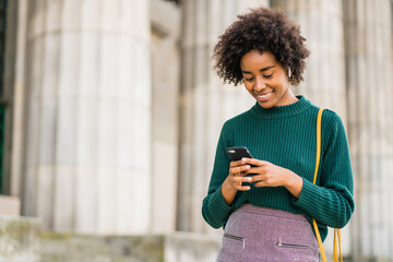 Business woman using her mobile phone outdoors.