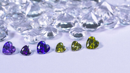 colorful diamond in heart shape are placed in a row on white diamonds background,