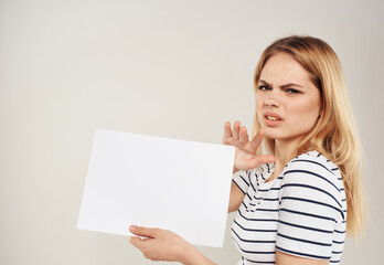 Naklejka premium Cute blonde model with white sheet of paper in hands
