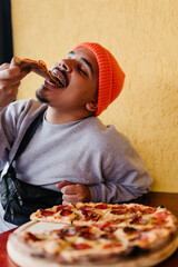 male model eating big pizza with his hand