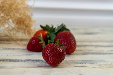 Strawberry in basket and on table on wooden background