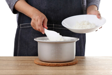 woman use rice spoon to scoop rice from pot on table