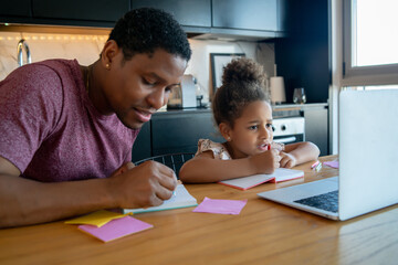 A father helping his daughter with homeschool.