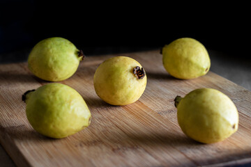 yellow guavas on canvas and wood, low key