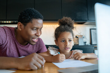 A father helping his daughter with homeschool.