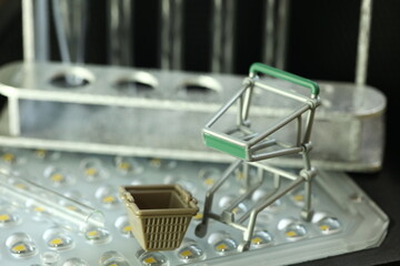 Miniature shopping trolley and basket represent retail science and consumerism concept related...