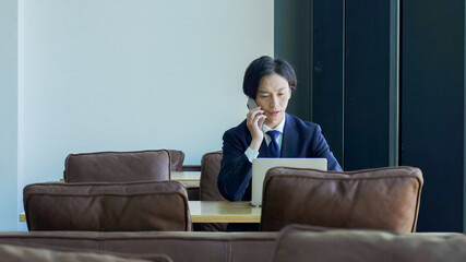 パソコンをしながら電話をするビジネスマン