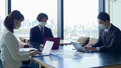 マスクをして打ち合わせをするビジネスマン