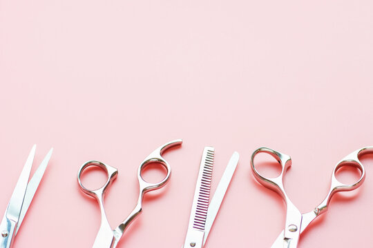 Professional scissors on pink background with copy space.