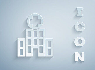 Paper cut Medical hospital building with cross icon isolated on grey background. Medical center. Health care. Paper art style. Vector