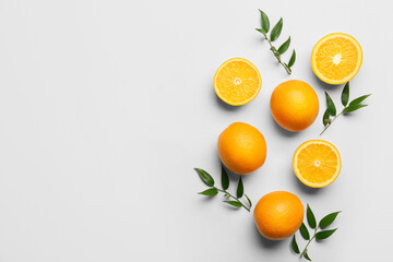 Fresh oranges with green leaves on white background