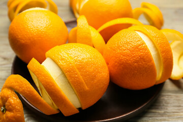 Fresh oranges with peel on wooden background