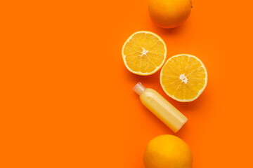 Bottle of cosmetic product with vitamin C and oranges on color background