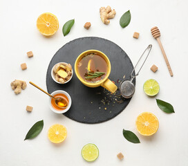 Composition with cup of tasty ginger tea and ingredients on white background