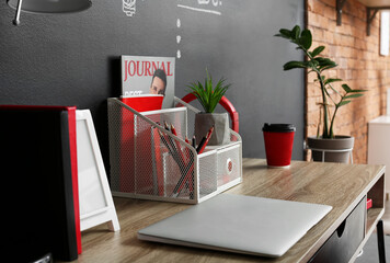 Modern organizer and laptop on table in interior of room - obrazy, fototapety, plakaty