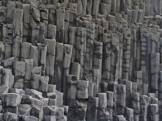 Closeup view of volcanic basalt columns on the famous Reynisfjara beach, a popular tourist...