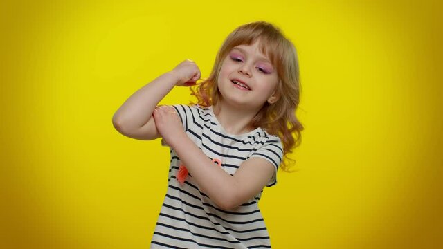 I am strong and independent. Little teen kid child girl showing biceps and looking confident feeling power strength to fight for rights, energy to gain success win. Young children on yellow background