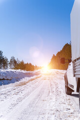 car on a winter road. Adventure. car on winter snowy road in mountains in sunny day. Vertical photo