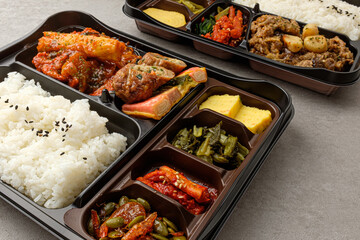Lunch box with rice, meat and vegetable side dishes