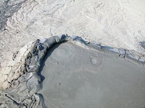 Mud volcano flowing down clayey mud mixed with hydrocarbons. Natural Reserve Salse of Nirano: Modena, Fiorano, Italy. - Powered by Adobe