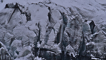 Closeup view of the breakoff edge of Sólheimajökull, an outlet glacier of Mýrdalsjökull (Katla), in the south of Iceland with ice surface of white and black pattern and crevasses in winter season.