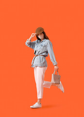 Fototapeta premium Fashionable young woman wearing mask on color background