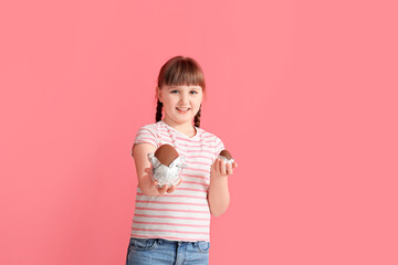 Cute little girl with chocolate Easter eggs on color background