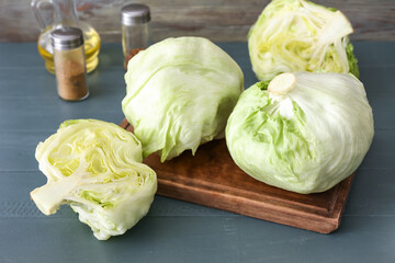 Iceberg lettuce with spices on color wooden background