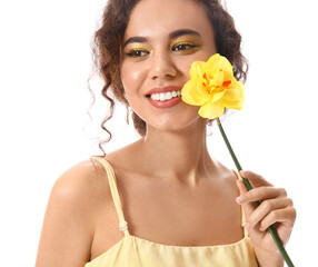 Beautiful young African-American woman with narcissus on white background