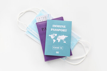 Immune passport, documents and medical masks on white background