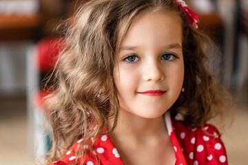Portrait of a five-year-old girl with painted lips with lipstick. Close up looking at the camera...