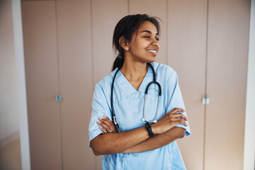 Joyful female doctor with stethoscope standing in clinic