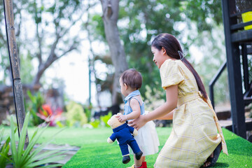 Happy mother and daughter walking in the garden