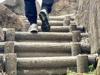 野外の階段を上る男性の足元